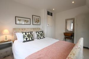 a bedroom with a large white bed with pillows at Marsh View, Southwold in Southwold