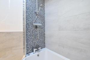 a bathroom with a shower and a bath tub at The Smokehouse Cottage in Southwold +22 photos