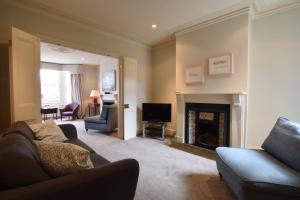 a living room with a couch and a fireplace at 14 Dunwich Road, Southwold in Southwold