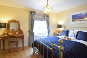 ein Schlafzimmer mit Bett, Schreibtisch und Fenster in der Unterkunft Parsley Cottage, Southwold in Southwold