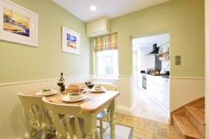 ein Esszimmer mit Tisch und Stühlen und eine Küche in der Unterkunft Parsley Cottage, Southwold in Southwold