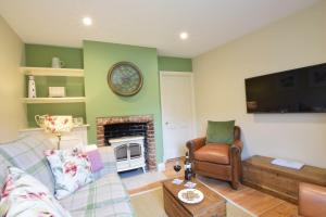 ein Wohnzimmer mit Couch und Kamin in der Unterkunft Parsley Cottage, Southwold in Southwold