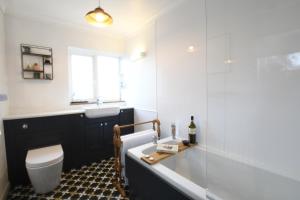a bathroom with a tub and a sink and a toilet at Rosedene, Rickinghall in Rickinghall