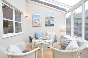 a room with a table and chairs and windows at Bluebelle Cottage, Peasenhall in Peasenhall