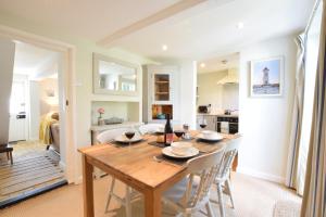 a kitchen and dining room with a wooden table and chairs at Satis Cottage, Westleton in Westleton