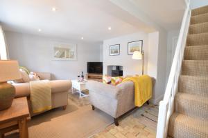 a living room with a couch and a chair at Satis Cottage, Westleton in Westleton