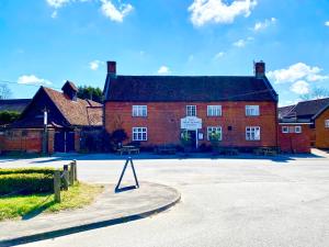 a large red brick building with a sign in front of it at Satis Cottage, Westleton in Westleton