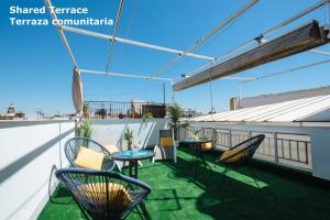 a patio with chairs and tables on a roof at SAH23 beautiful studio in the center in Seville
