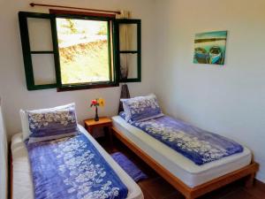 two beds in a room with a window at Casa Flor azul in Las Tricias