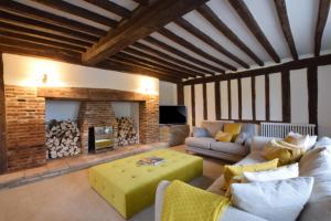 a living room with a couch and a fireplace at Old Bloxhall House, Hitcham in Lavenham