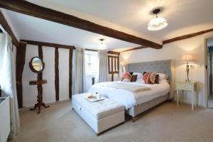 a bedroom with a large bed and a mirror at Old Bloxhall House, Hitcham in Lavenham