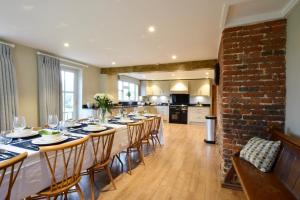 a dining room with a long table and chairs at Old Bloxhall House, Hitcham in Lavenham