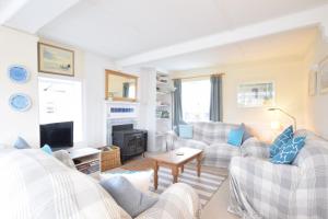 uma sala de estar com sofás e uma lareira em 5 Blackshore, Southwold em Southwold