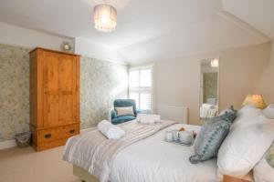 a bedroom with a white bed with a blue chair at The Teepee, Southwold in Southwold
