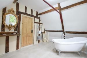y baño con bañera blanca y espejo. en Church Farmhouse, Cookley, en Halesworth 25 fotos más