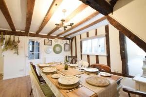 a dining room with a wooden table and chairs at Church Farmhouse, Cookley in Halesworth