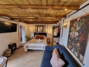 a bedroom with a bed and a couch in a room at El Nido Fuente Hervera. Precioso Loft con Bañera de Hidromasaje in Vega de San Mateo
