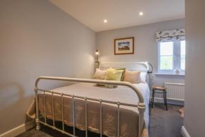 Una cama o camas en una habitación de Caines Cottage, Westleton