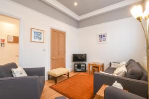 ein Wohnzimmer mit 2 Sofas und einem TV in der Unterkunft 1 Eversley Court, Southwold in Southwold