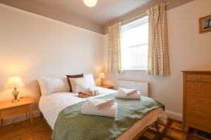 ein Schlafzimmer mit einem Bett mit zwei Handtüchern darauf in der Unterkunft 1 Eversley Court, Southwold in Southwold