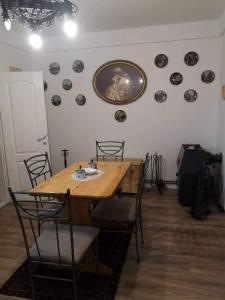 - une salle à manger avec une table et des chaises en bois dans l'établissement Apartman CUNI, à Subotica
