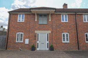 a red brick house with a white door at 1 Coconut Cottage, Long Melford in Long Melford