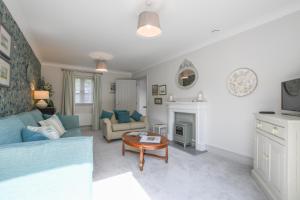 a living room with a blue couch and a table at 1 Coconut Cottage, Long Melford in Long Melford