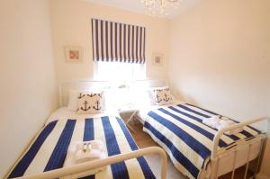 2 Einzelbetten in einem Zimmer mit Fenster in der Unterkunft High Tide, Crabbe Street, Aldeburgh in Aldeburgh