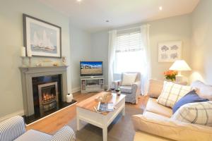 ein Wohnzimmer mit einem Sofa und einem Kamin in der Unterkunft High Tide, Crabbe Street, Aldeburgh in Aldeburgh