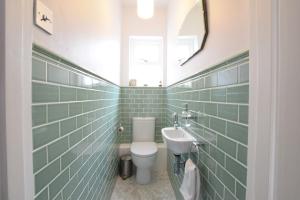 a bathroom with a toilet and a sink at Driftwood, Southwold in Southwold