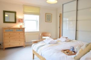 ein Schlafzimmer mit einem Bett mit Handtüchern und einer Kommode in der Unterkunft Peach House, Aldeburgh in Aldeburgh
