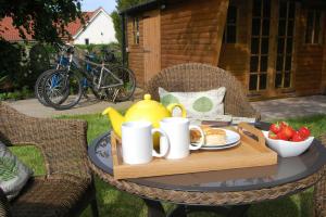 una mesa con una bandeja de comida para el desayuno. en Shoemakers Cottage, Friston, en Friston
