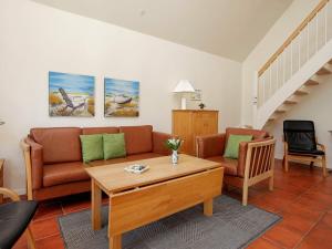 a living room with a couch and a table at 4 person holiday home in Bl vand in Blåvand