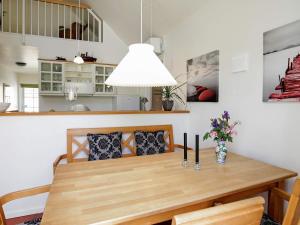 una sala da pranzo con tavolo e sedie in legno di 4 person holiday home in Bl vand a Blåvand