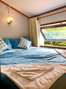 een slaapkamer met een blauw bed en een raam bij Baan Chan Lay Koh Chang in Ko Chang
