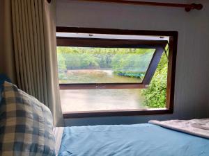 a bedroom with a window with a view of a river at Baan Chan Lay Koh Chang in Ko Chang