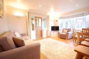 uma sala de estar com um sofá e uma sala de jantar em Garden Cottage, Southwold em Southwold