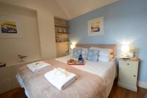 um quarto com uma cama com toalhas em Garden Cottage, Southwold em Southwold