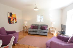 a living room with purple chairs and a couch at Fig Cottage, Pettistree in Woodbridge