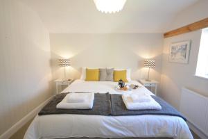 1 dormitorio con 1 cama grande y toallas. en Fig Cottage, Pettistree, en Woodbridge