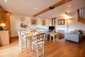 a kitchen and living room with a table and chairs at Three Chantry Barns, Orford in Orford