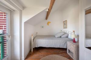 a white bedroom with a bed and a window at Maison de caractere a 100 metres de la plage in Le Pouliguen