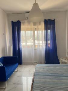 a bedroom with blue curtains and a bed and a chair at Atmosfera B&B al centro della città in Cosenza