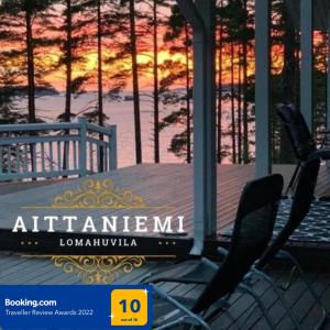 a couple of chairs sitting on a porch with a sunset at Elegant villa on the shore of Lake Saimaa in Lappeenranta