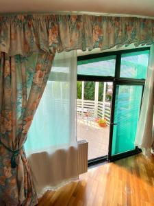 um quarto com uma grande janela com vista para um pátio em Cozy rooms in wine town - Modra em Modra