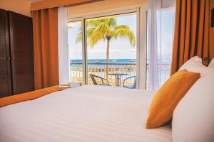 Schlafzimmer mit einem Bett und Meerblick in der Unterkunft Hotel Bakoua Martinique in Les Trois-Îlets