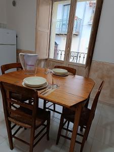 una mesa de madera con sillas y platos. en Casetta nel Borgo Pianello con vista panoramica, en Muro Lucano