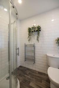 ein weißes Bad mit einer Dusche und einem WC in der Unterkunft Albert Rd by The V Group in Blackpool