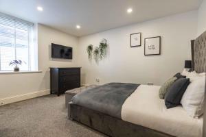 ein Schlafzimmer mit einem Bett, einer Kommode und einem Fenster in der Unterkunft Albert Rd by The V Group in Blackpool