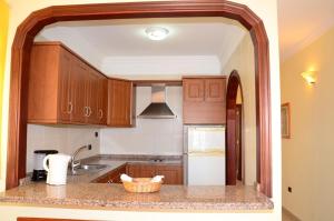a kitchen with wooden cabinets and a counter top at Apartamentos Callaomar in Callao Salvaje
